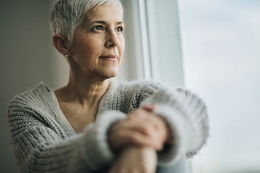 Woman with short hair looking out of a window happy with her dental implants from Wanserski Dental Center for Complex Dentistry in Wausau, WI